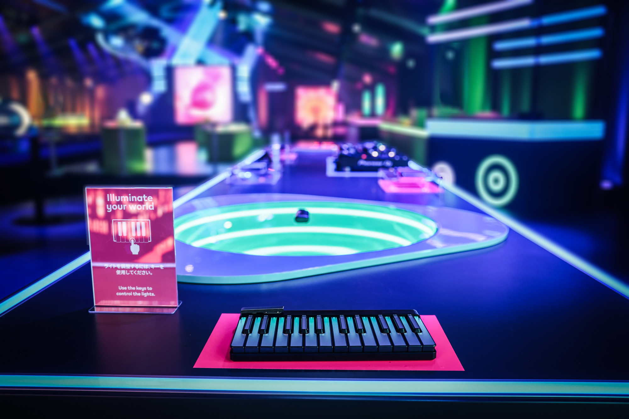 Interactive neon-lit event setup featuring a futuristic keyboard control panel and illuminated circular installation Battle Royal Studios